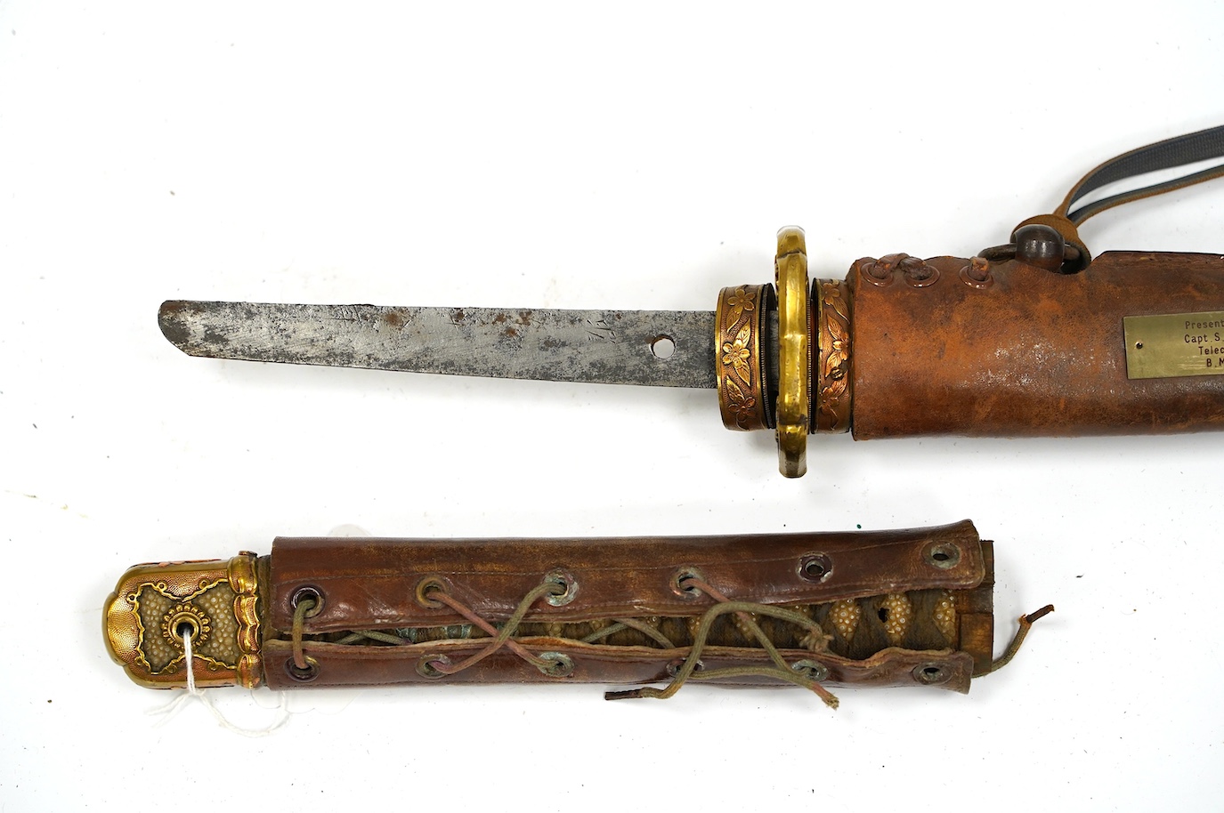 A Japanese WWII army officer’s sword Katana, blade 57.9cm, signed and dated with Seki Arsenal stamp, retaining good polish, in shin gunto mounts with leather combat cover on hilt and scabbard, the latter with plate stamp